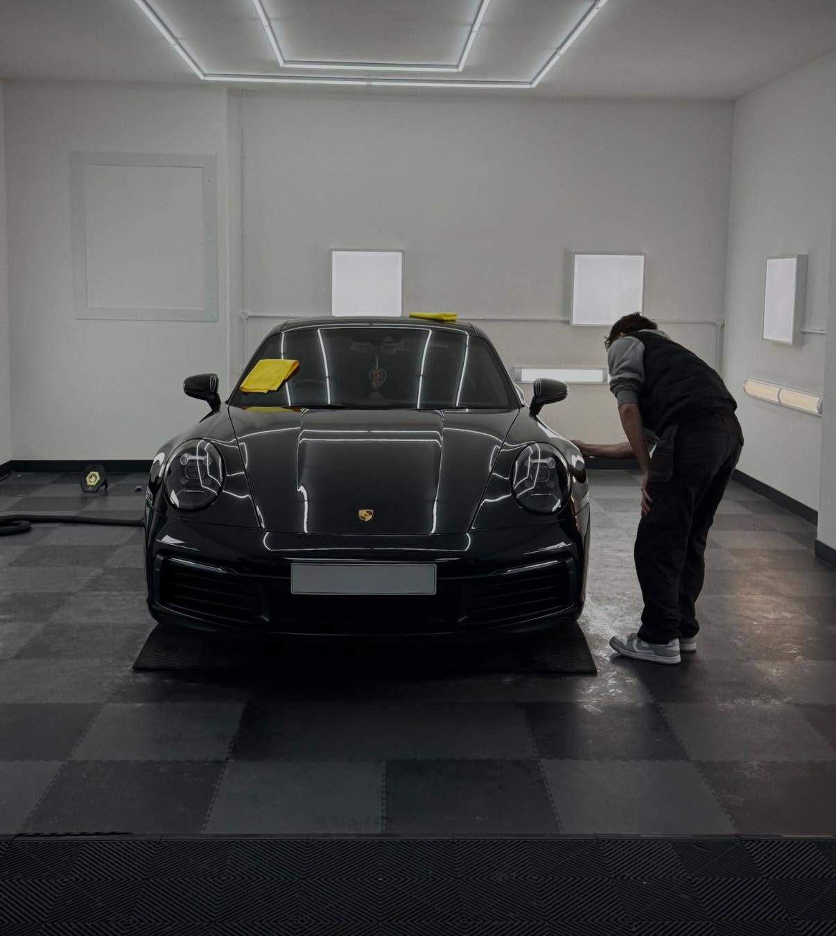Rhys inspecting a black Porsche 911